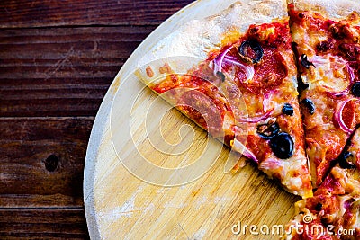 Delicious pizza on top view. Yummy pizza with pepperoni, vegetables, mozzarella cheese, black olives on wooden table, dish. Itâ€™s Stock Photo